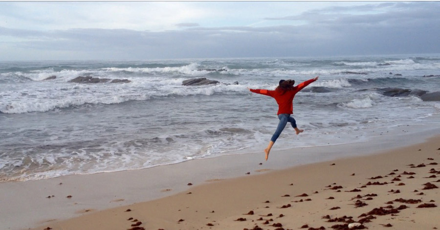 Frau spingt am Strand